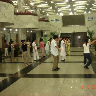 Los trabajadores de hospital practican Tai Ji - Qi Gong en la entrada del hospital